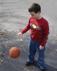 boy dribbling ball wearing red screen printed shirt
